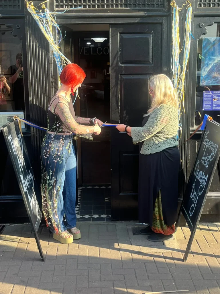 Two people cutting a ribbon
