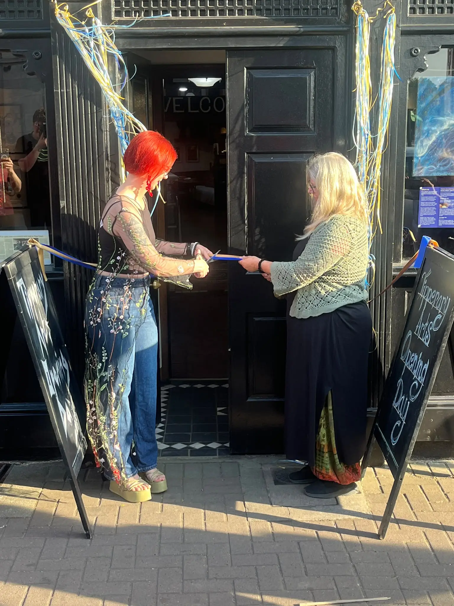 Two people cutting a ribbon